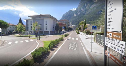 eine leere Straße mit einem Gebäude und einem Berg in der Unterkunft casa Dante in Riva del Garda