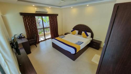 a bedroom with a bed and a large window at Palolem Inn in Palolem