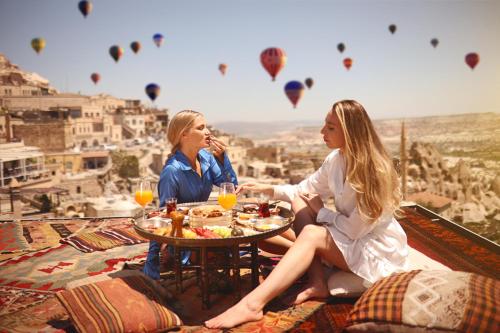 two women sitting at a table looking at hot air balloons at Mak's Cave House in Uchisar
