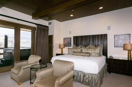 ein Schlafzimmer mit einem großen weißen Bett und Stühlen in der Unterkunft Premium Luxury Three Bedroom Suite with Hot Tub apartment hotel in Park City