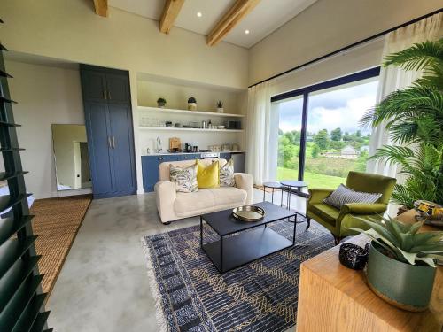 a living room with a couch and a table at Little Prestwick on Gowrie Farm, Nottingham Road in Nottingham Road