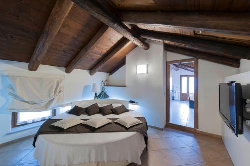a bedroom with a large bed and a tv at Hotel Ultimo Borgo in Settimo Torinese