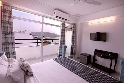 a bedroom with a bed and a large window at The Lake View Hotel- On Lake Pichola in Udaipur