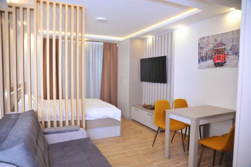 una camera d'albergo con letto e tavolo con sedie di Apartman A20B a Kopaonik