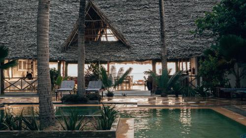 um resort com piscina em frente a um edifício em Sahari Zanzibar em Bwejuu