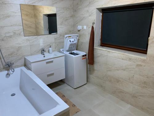 a white bathroom with a sink and a mirror at Bystravilla in Bystrá
