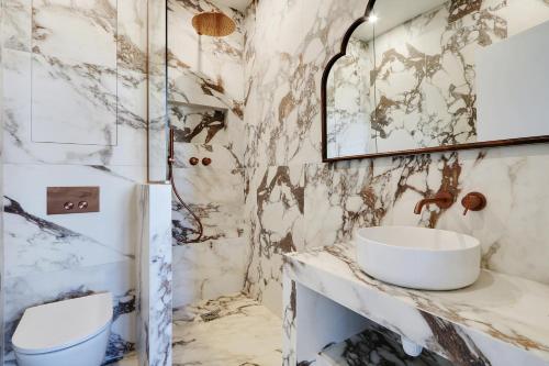 une salle de bain avec un lavabo et un miroir dans l'établissement Pick A Flat's Apartment in Opéra - Rue Saint Marc, à Paris