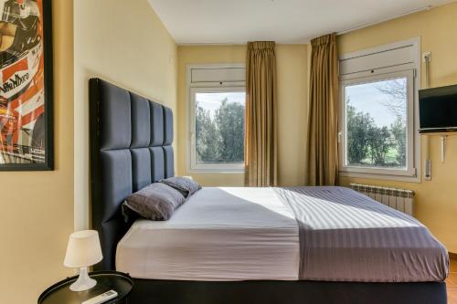 1 dormitorio con 1 cama grande y 2 ventanas en Can Miquel, en Torroella de Fluvià