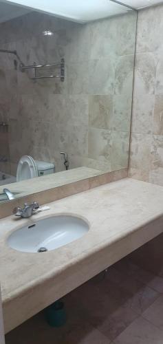 een badkamer met een wastafel en een spiegel bij SAB R.CONDOTEL and room rental in Manilla