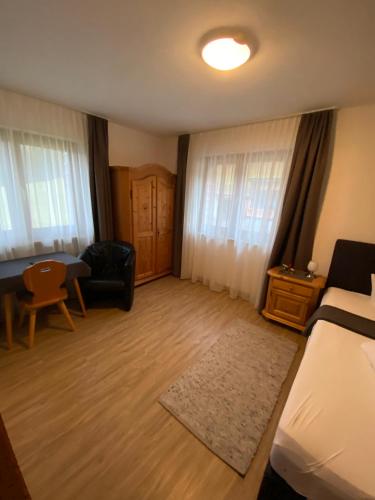 a bedroom with a bed and a couch and a chair at Pension Aschlandhof in Obsteig