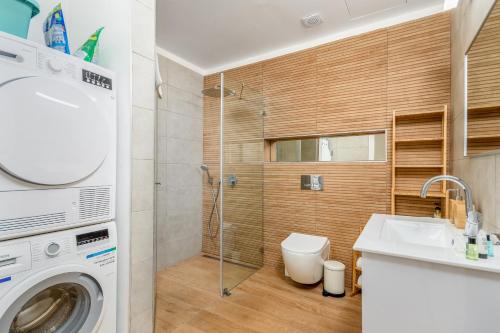 uma casa de banho com um lavatório e uma máquina de lavar roupa em Superb penthouse north tel aviv em Tel Aviv