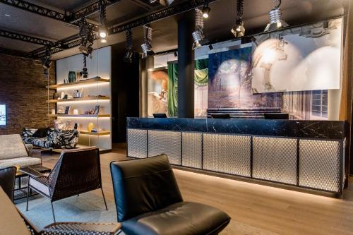a bar in a room with a couch and chairs at Motel One Stuttgart-Mitte in Stuttgart