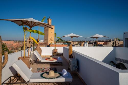 un balcone con sedie e ombrelloni sul tetto di Riad MedJad & Spa a Marrakech