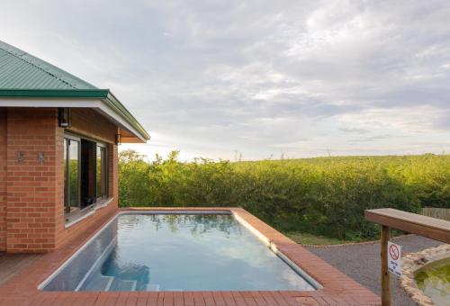 a swimming pool in the backyard of a house at Rockfig Lodge Madikwe in Madikwe Game Reserve