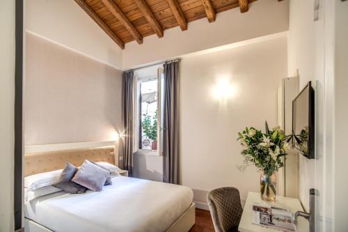 una camera d'albergo con letto e tavolo di Hotel San Silvestro a Roma