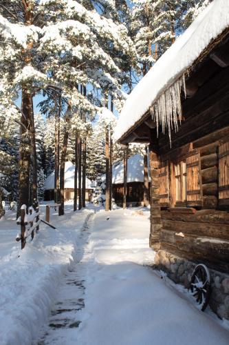 a log cabin in the snow with icicles on it at Gungas in Ādaži