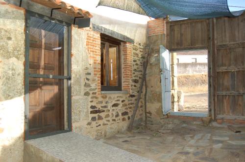 an outside view of a building with a door and windows at Casita del jardin in El Bodón