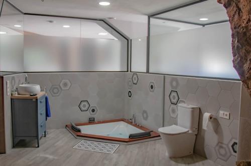 a bathroom with a bath tub and a toilet at Casa Cueva Mojácar "Jacuzzi & Sea View" en Almería in Mojácar
