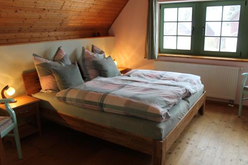 1 dormitorio con cama con almohadas y ventana en Ferienhaus Schellerhäusl en Kurort Altenberg