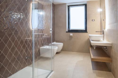 un bagno con un water e un lavandino di Villa Divina22- APT Icona con piscina e vista lago a Castelletto di Brenzone
