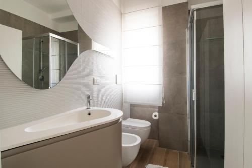 y baño con lavabo, aseo y espejo. en Casa Armonia by MONHOLIDAY en Monopoli