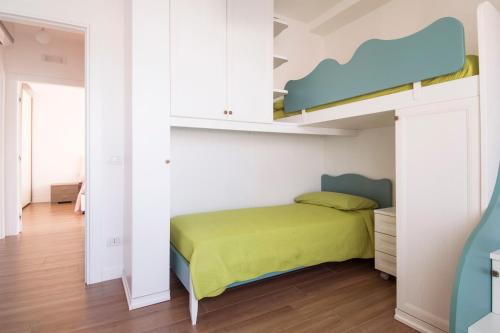 1 dormitorio con 1 cama con colcha verde en Casa Armonia by MONHOLIDAY en Monopoli