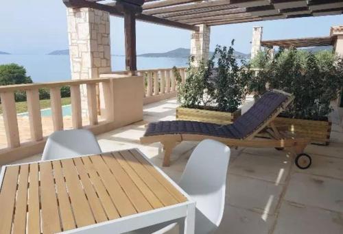 a patio with chairs and a table and a bench at Therme Sea Luxury Lodge in Thermisia