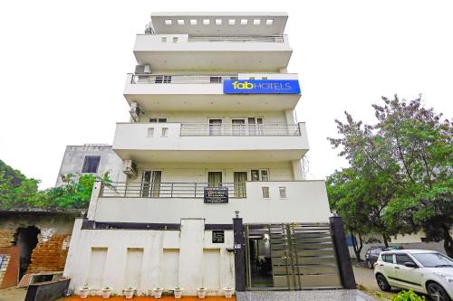 un edificio blanco alto con un letrero. en FabHotel White House BNB en Nueva Delhi