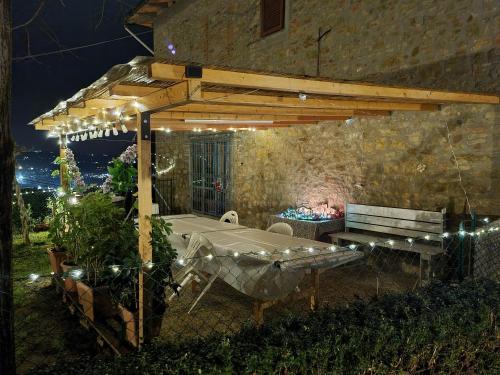 a patio with a table and a bench under a pergola at Agriturismo Villino del Grillo in San Gimignano