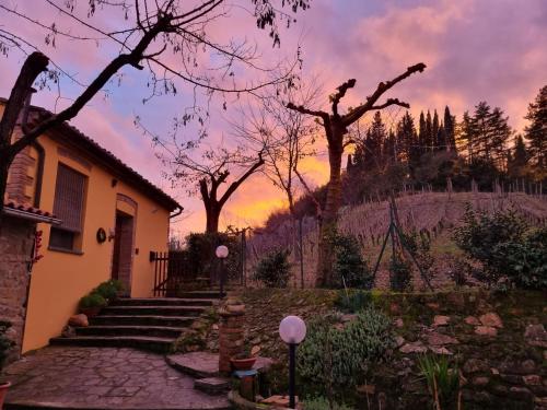 a house with a sunset in the background at Agriturismo Villino del Grillo in San Gimignano
