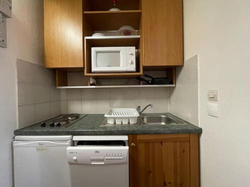 une petite cuisine avec un évier et un micro-ondes dans l'établissement Double Studios avec vue sur glacier, à Les Deux Alpes