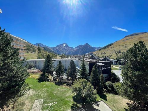 - une vue aérienne sur un bâtiment avec des arbres et des montagnes dans l'établissement Double Studios avec vue sur glacier, à Les Deux Alpes