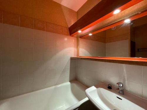 une salle de bain avec une baignoire blanche et un lavabo dans l'établissement Double Studios avec vue sur glacier, à Les Deux Alpes