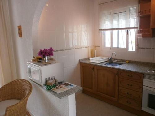 eine Küche mit einer Spüle und einer Theke mit einer Mikrowelle in der Unterkunft Self Contained hillside Villa with stunning vistas in Castillo del Reboller