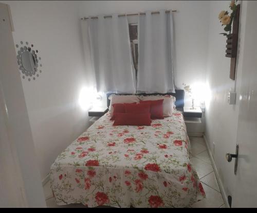 - une chambre avec un lit doté d'oreillers rouges et une fenêtre dans l'établissement Confortável apartamento no centro ano bom, à Barra Mansa