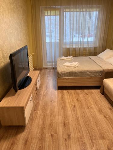 um quarto com uma cama e uma televisão de ecrã plano em Prisma Apartment em Talin