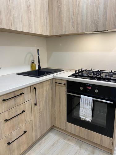 a kitchen with a stove and a sink at Vakariniai Apartamentai in Panevėžys