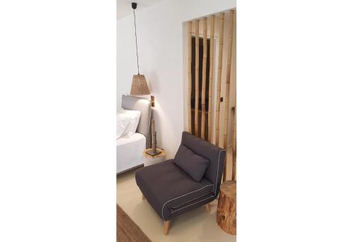 a living room with a chair and a bed at Therme Sea Luxury Lodge in Thermisia