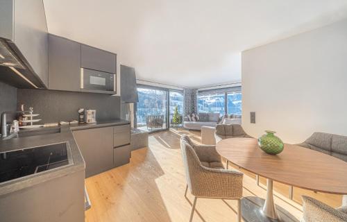 a kitchen and a living room with a table in a room at Villa Carolina in Selva di Val Gardena
