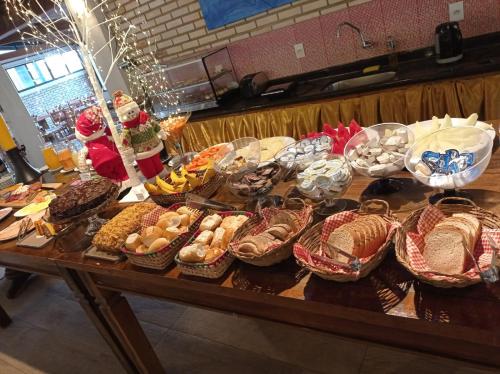 a table filled with lots of baskets of food at Silvestre Praia Hotel in Imbituba
