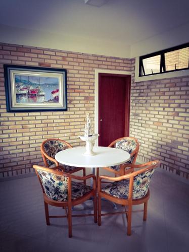 a dining room with a white table and chairs at Silvestre Praia Hotel in Imbituba