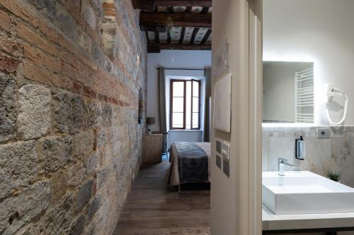 a bathroom with a sink and a brick wall at B&B Governo dei Nove in Siena