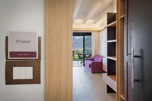 einen Flur mit einem Wohnzimmer mit einem lila Sofa in der Unterkunft Villa Divina - APT Prima con piscina e vista lago in Castelletto di Brenzone