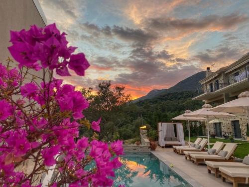 uma casa com piscina com flores roxas em Charisma Boutique Hotel em Parga