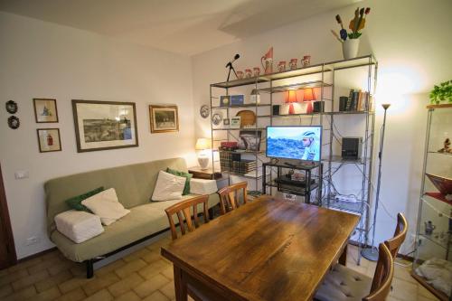 ein Wohnzimmer mit einem Tisch und einem Sofa in der Unterkunft Holiday House Torre del Lago in Torre del Lago Puccini