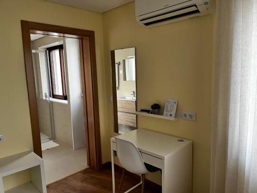 a room with a white desk and a mirror at Aliança Alojamento Local in Guarda