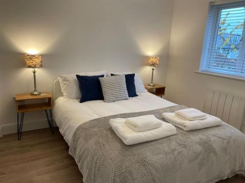 a bedroom with a large bed with two towels on it at The Old Printworks, with parking and patio garden in Whitstable