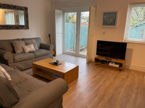 ein Wohnzimmer mit Couch und Flachbildfernseher in der Unterkunft The Old Printworks, with parking and patio garden in Whitstable