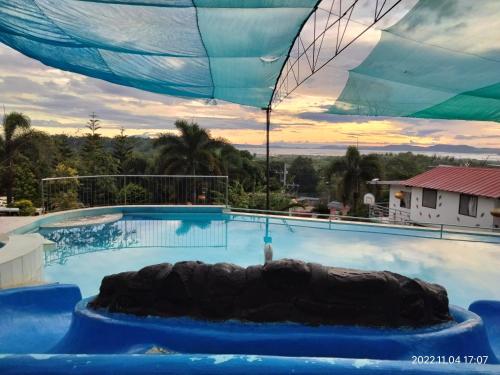 a large swimming pool with an umbrella over it at Casa de Robles Tanay Rizal in Tanay