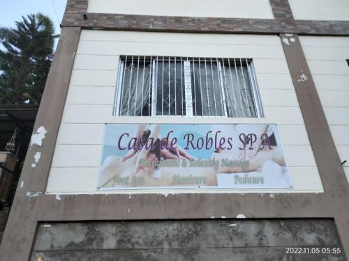 a sign on the side of a building with a cross at Casa de Robles Tanay Rizal in Tanay
